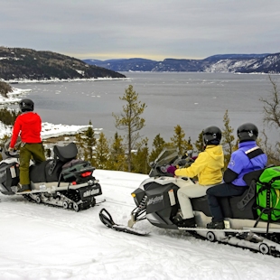 Snowmobilers in front of the Saguenay fjord